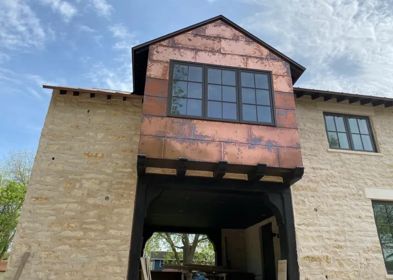 Copper metal panel facade on a stone building for Skylight Installation in Calera