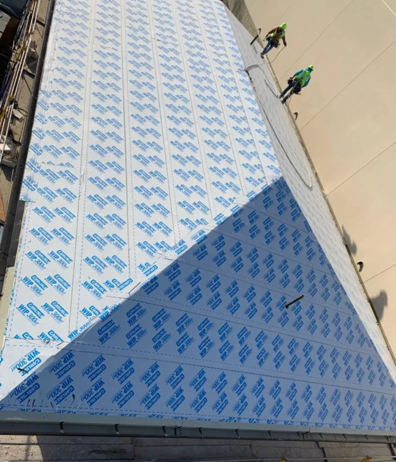 Professional roofers installing underlayment on a metal roof in Calera